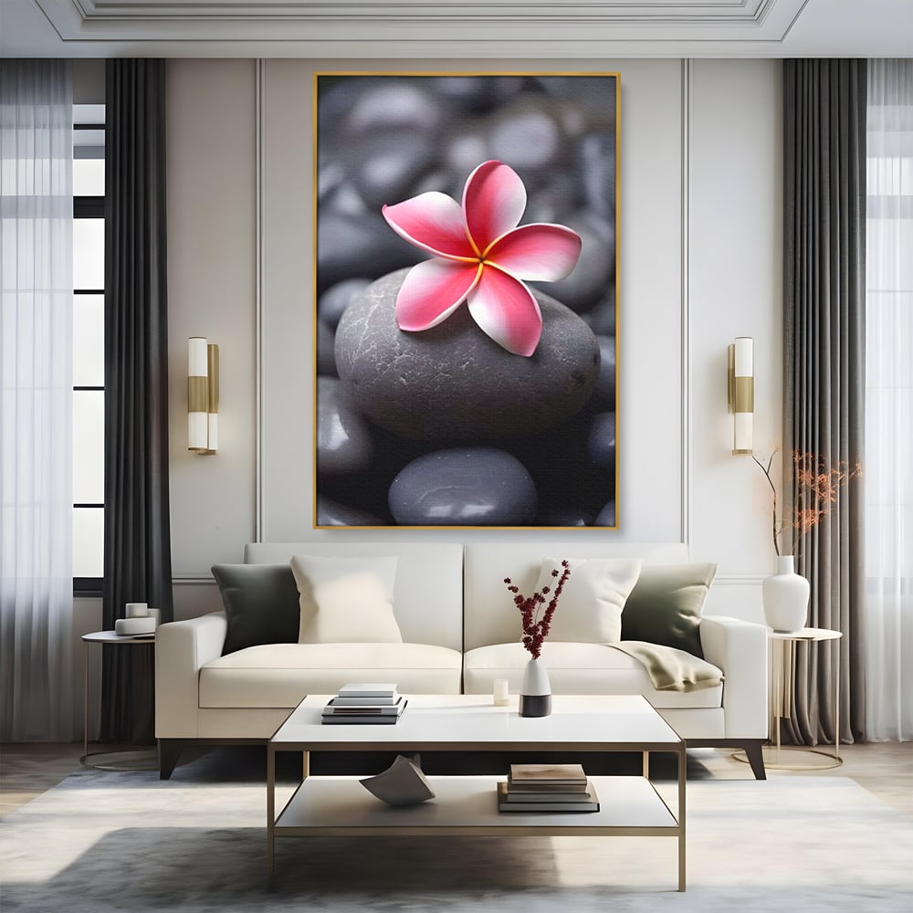 Tablou canvas cu floare roz pe pietre gri, in rama de aluminiu auriu, pe perete intr-un living